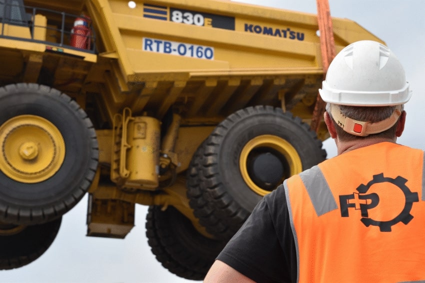 Crane lifting a Komatsu 830E dump truck
