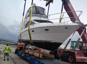 Luxury sailing yacht being crane lowered for transportation