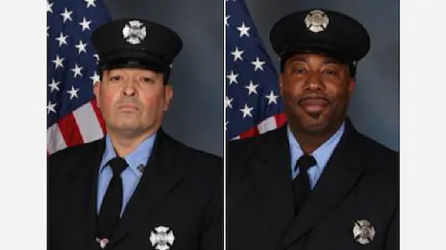 Two headshots of firemen in their formal uniform. Dark suit, tie, and hat with blue button up shirt and badges on their chests and hats. In the background flies the American gflag